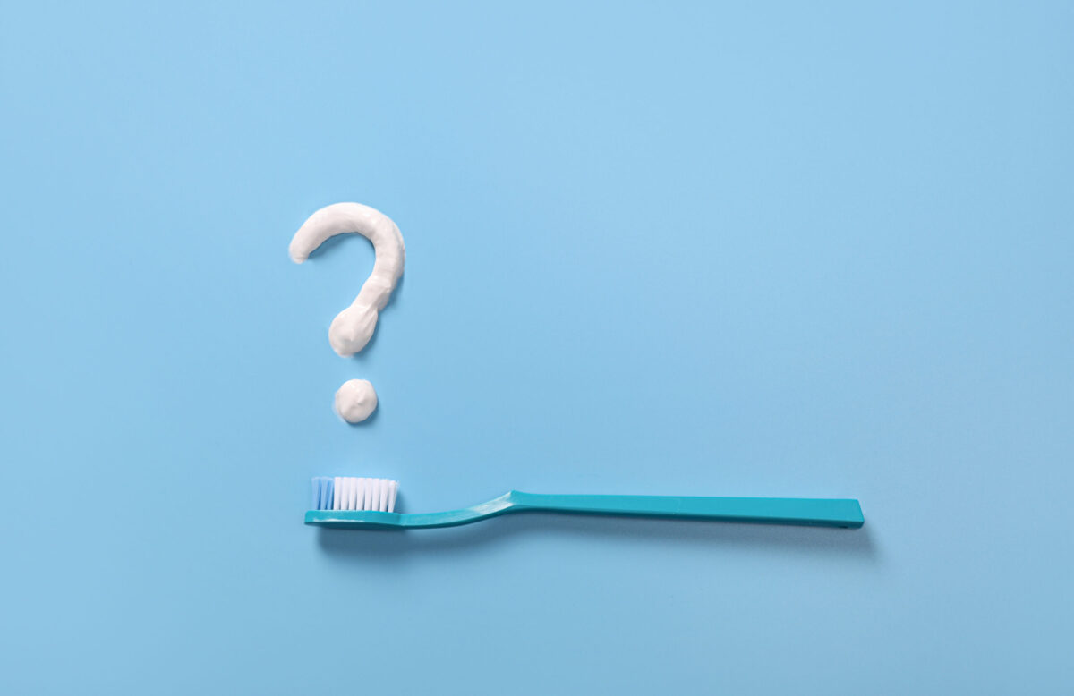 Plastic toothbrushes with toothpaste question mark